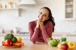 nutrizionista appoggiata sul tavolo con frutta e verdura