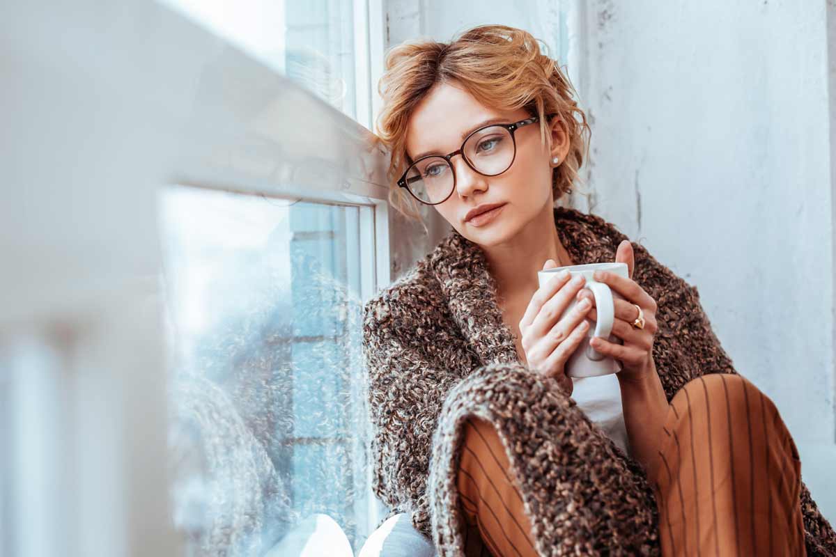 donna in finestra con tazza di tè