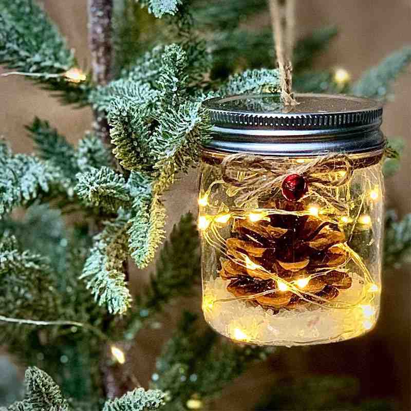 mini lanterna con pigna appesa all'albero di Natale